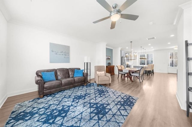 living room featuring hardwood / wood-style floors, ornamental molding, and ceiling fan