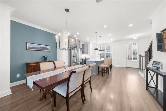 dining room featuring ornamental molding, sink, and hardwood / wood-style floors