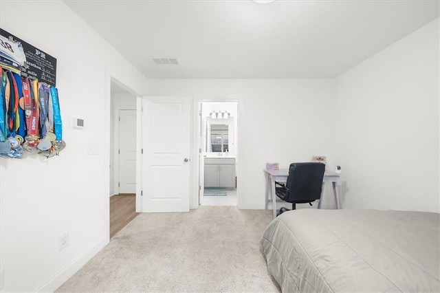 carpeted bedroom featuring ensuite bath