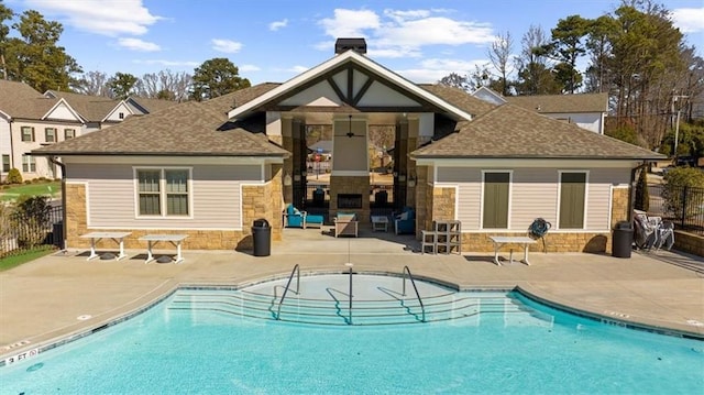 back of house featuring a community pool, a fireplace, and a patio area