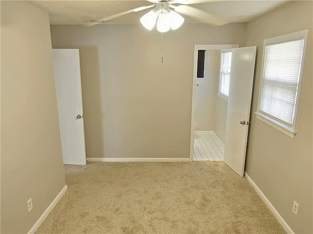 carpeted empty room featuring ceiling fan