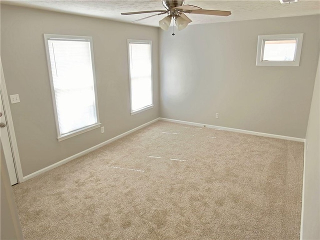 empty room featuring ceiling fan and light carpet