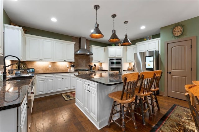 4 Bluff Ct, Cartersville, GA 30120 - kitchen featuring wall chimney range hood, appliances with stainless steel finishes, a kitchen island, white cabinets, and recessed lighting