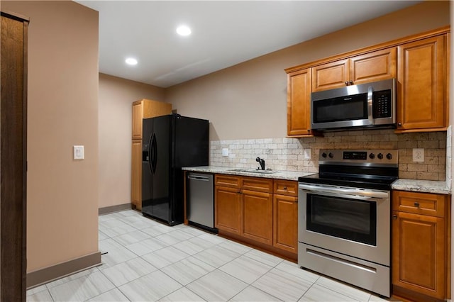 4 Bluff Ct, Cartersville, GA 30120 - kitchen with stainless steel appliances, tasteful backsplash, brown cabinets, light stone countertops, and recessed lighting