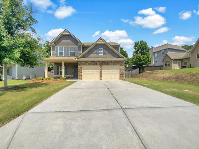 craftsman-style home with a front lawn, central AC unit, and a garage