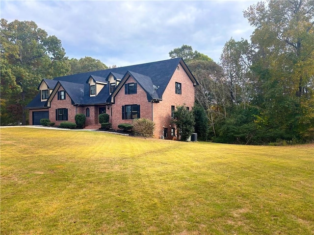 view of front of house featuring brick siding, a garage, and a front yard