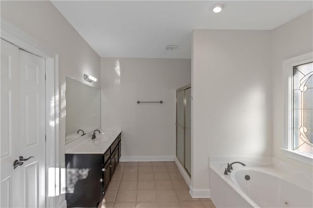 bathroom with tile patterned floors, a garden tub, a stall shower, baseboards, and vanity