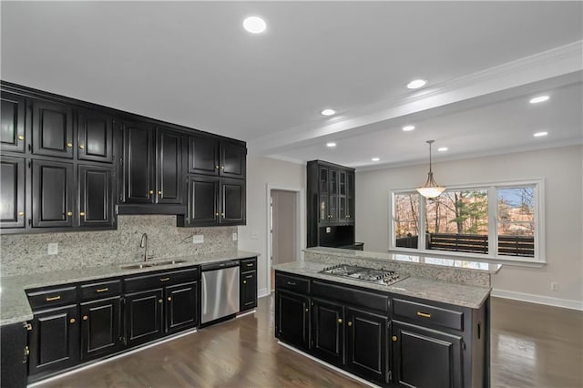 kitchen with dark cabinetry, tasteful backsplash, appliances with stainless steel finishes, and a sink