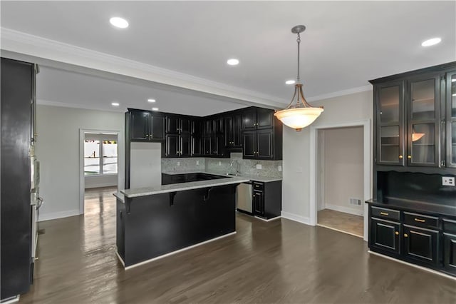 kitchen featuring a center island, crown molding, decorative backsplash, dark cabinetry, and dark wood-style floors