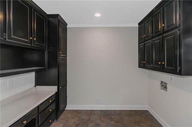 kitchen featuring baseboards, dark cabinets, and crown molding