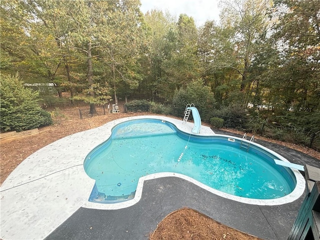 pool featuring a diving board and a water slide