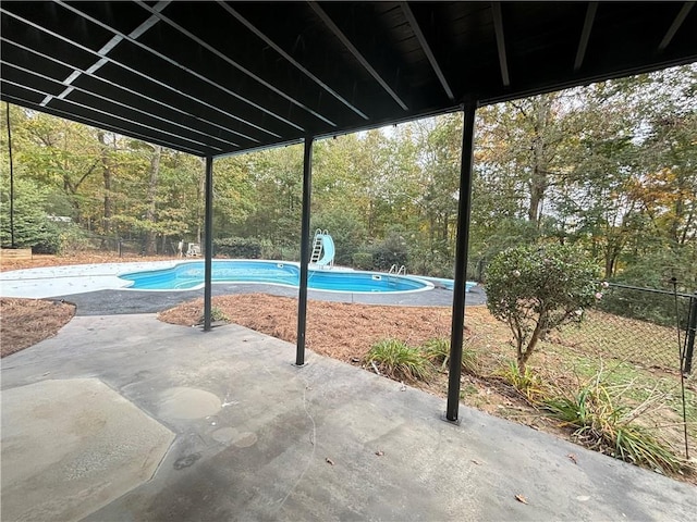 outdoor pool featuring a patio, a water slide, and a fenced backyard