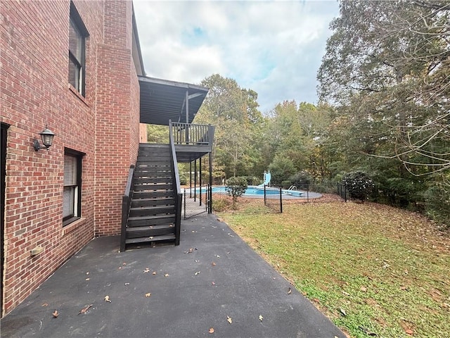 view of yard featuring stairway, fence, an outdoor pool, and a wooden deck