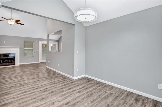 unfurnished living room featuring high vaulted ceiling, hardwood / wood-style flooring, and ceiling fan