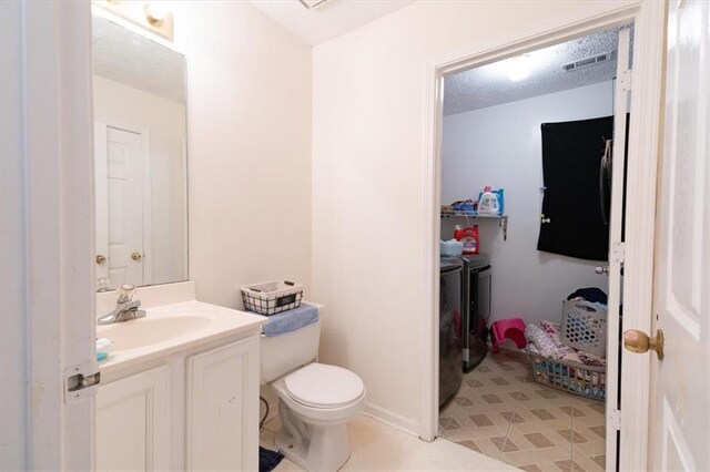 bathroom featuring vanity, toilet, and washing machine and clothes dryer