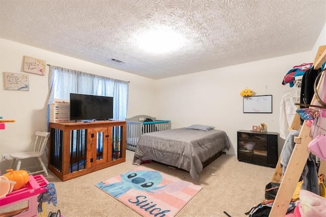 bedroom with a textured ceiling and light colored carpet