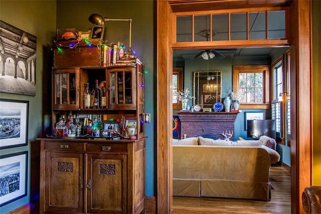 bar featuring a bar, wood finished floors, and a fireplace