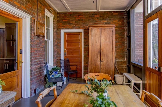 dining area featuring brick wall