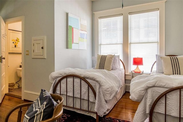 bedroom featuring electric panel and wood finished floors