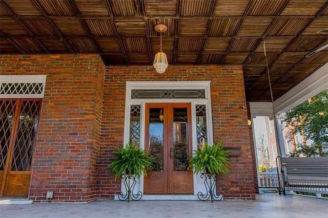 doorway to property featuring brick siding and french doors