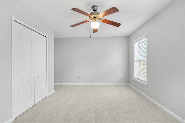 unfurnished bedroom with light carpet, a closet, and ceiling fan