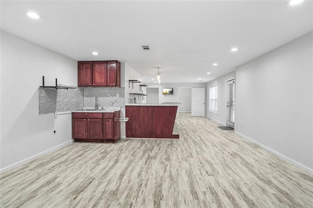 kitchen with light wood-type flooring, sink, and tasteful backsplash