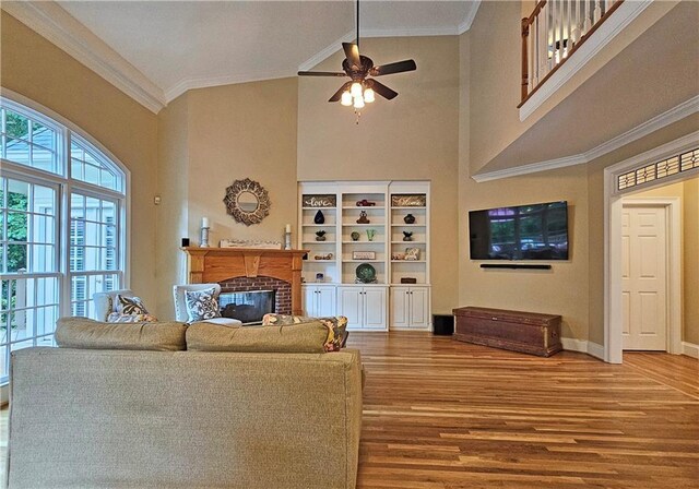 215 Settindown Ct, Roswell, GA 30075 - living room featuring wood finished floors, a high ceiling, ceiling fan, a fireplace, and ornamental molding