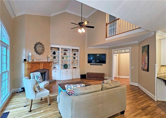 215 Settindown Ct, Roswell, GA 30075 - living area featuring wood finished floors, crown molding, a brick fireplace, high vaulted ceiling, and healthy amount of natural light