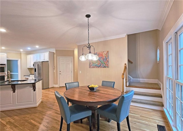 215 Settindown Ct, Roswell, GA 30075 - dining area with crown molding, a chandelier, stairs, light wood-style floors, and recessed lighting