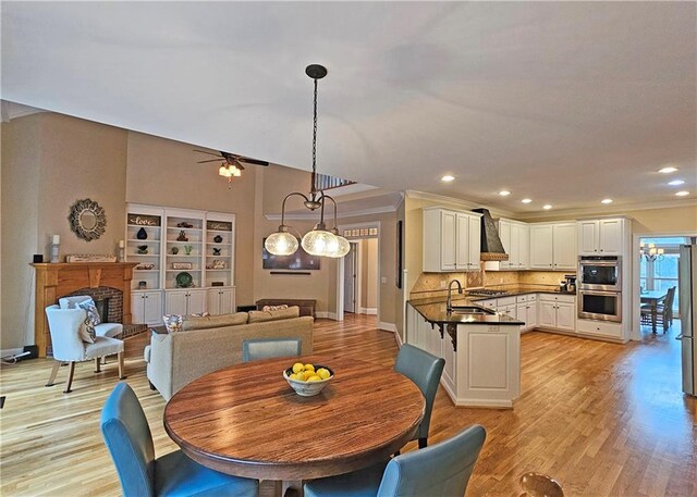 215 Settindown Ct, Roswell, GA 30075 - dining space featuring a ceiling fan, light wood-type flooring, a fireplace, recessed lighting, and ornamental molding