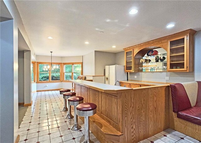 215 Settindown Ct, Roswell, GA 30075 - kitchen with white fridge with ice dispenser, recessed lighting, light countertops, glass insert cabinets, and brown cabinets