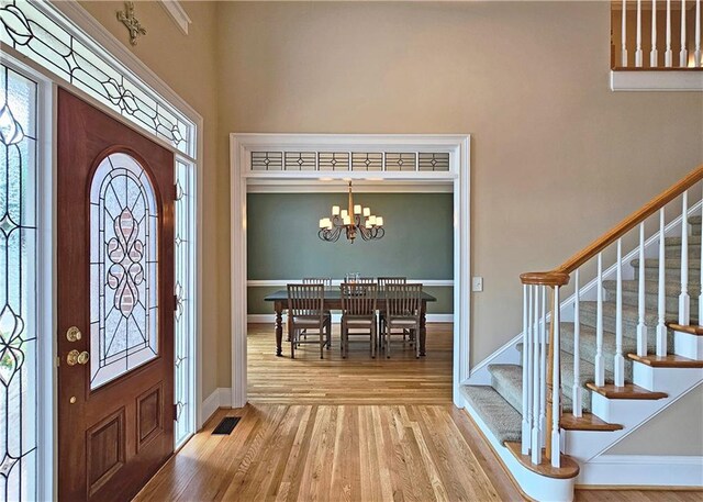 215 Settindown Ct, Roswell, GA 30075 - entrance foyer with wood finished floors, stairs, a chandelier, plenty of natural light, and a high ceiling