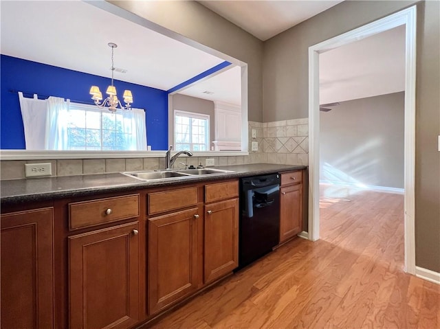 kitchen with sink, dishwasher, light wood-type flooring, decorative light fixtures, and an inviting chandelier