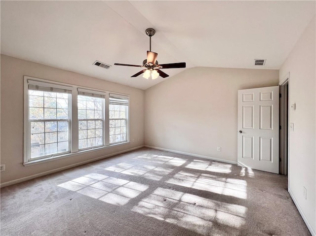 spare room with vaulted ceiling, light colored carpet, and ceiling fan