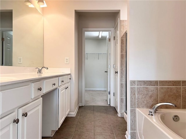 bathroom with vanity, a bathtub, and tile patterned flooring