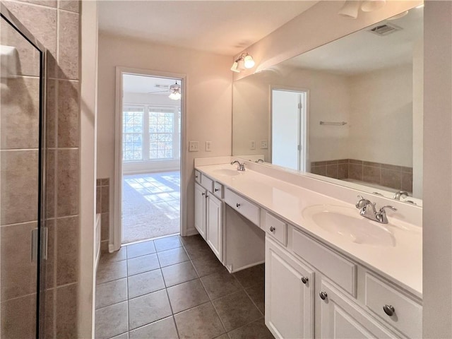 bathroom with a shower with door, vanity, ceiling fan, and tile patterned floors