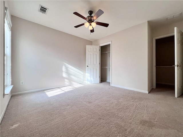 unfurnished bedroom with a closet, light colored carpet, and ceiling fan