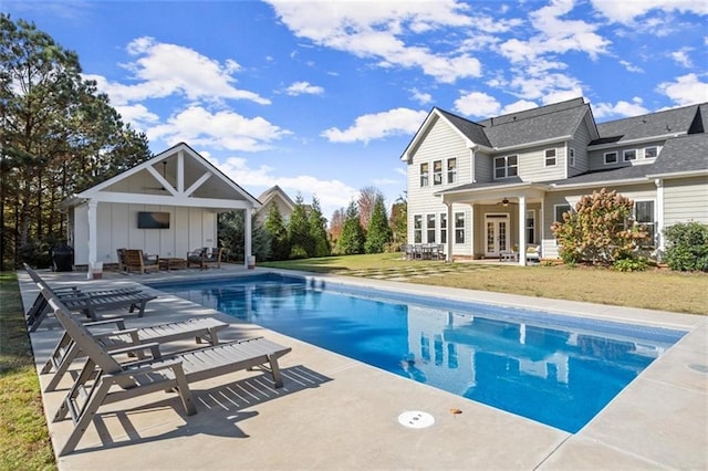 view of swimming pool with a patio, a yard, ceiling fan, and french doors