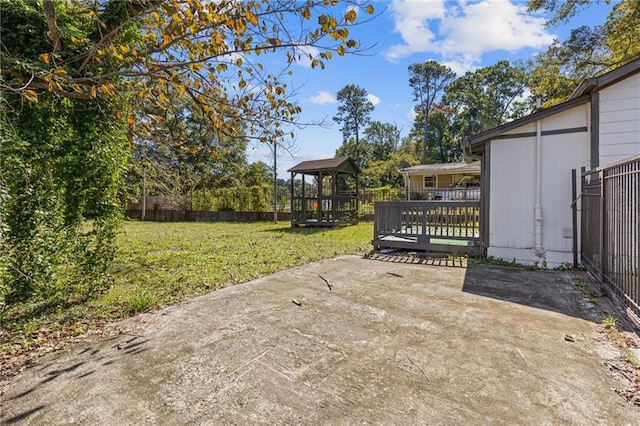 view of gate featuring a yard, a patio area, and a gazebo