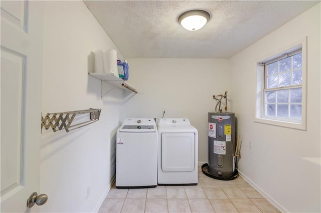 washroom featuring electric water heater, a textured ceiling, separate washer and dryer, laundry area, and baseboards