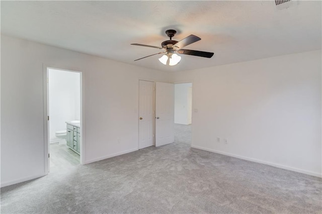 spare room featuring light carpet, ceiling fan, visible vents, and baseboards