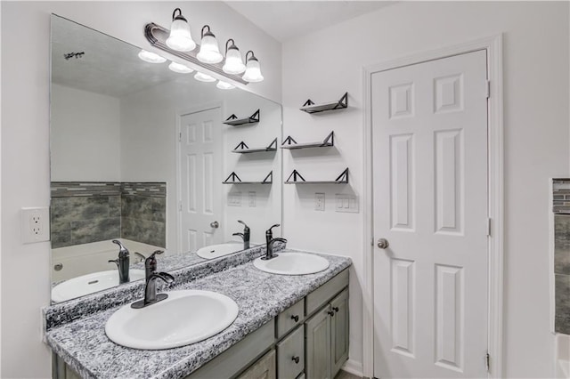 bathroom featuring double vanity, a bathing tub, and a sink