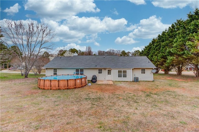 rear view of house featuring a yard, a patio, cooling unit, and an outdoor pool