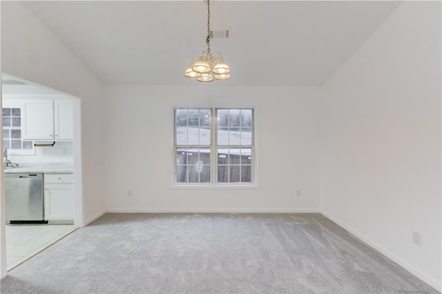 unfurnished dining area featuring a chandelier, baseboards, visible vents, and light colored carpet