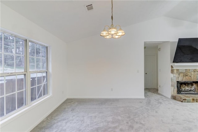 unfurnished living room featuring visible vents, vaulted ceiling, carpet flooring, a fireplace, and a notable chandelier