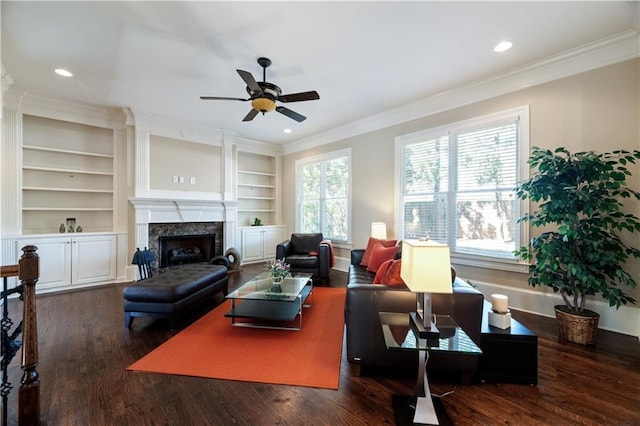 living room featuring recessed lighting, dark wood-type flooring, ornamental molding, and a high end fireplace