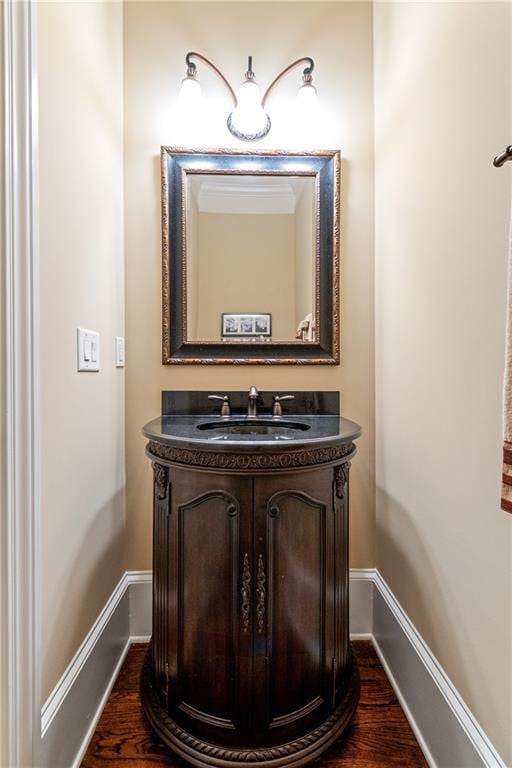 bathroom with baseboards, wood finished floors, and vanity