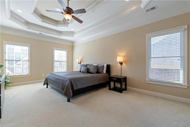 carpeted bedroom featuring a tray ceiling, baseboards, visible vents, and ornamental molding