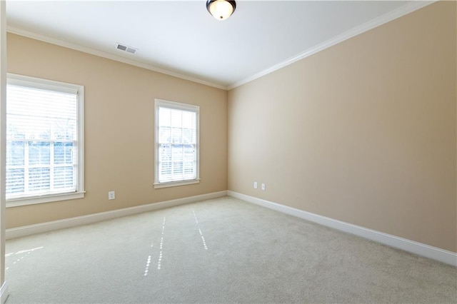 spare room with light colored carpet, a healthy amount of sunlight, and ornamental molding