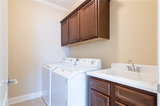 clothes washing area with baseboards, ornamental molding, cabinet space, independent washer and dryer, and a sink